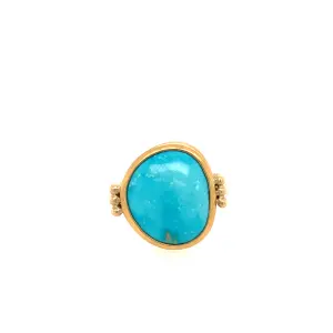 Turquoise gemstone ring with a gold setting, featuring an oval-shaped stone and decorative side details, perfect for adding a pop of color to any outfit.