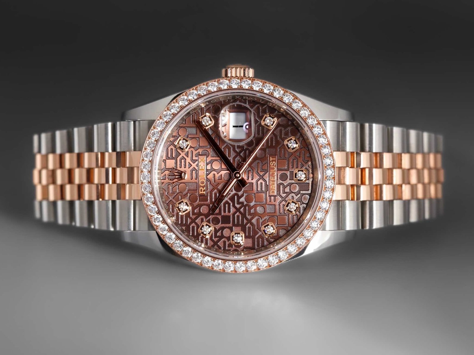 Rolex Datejust watch featuring a brown patterned dial, surrounded by a diamond-encrusted bezel. The timepiece has a two-tone stainless steel and rose gold bracelet, showcasing luxury and elegance. Ideal for collectors and enthusiasts of high-end watches.